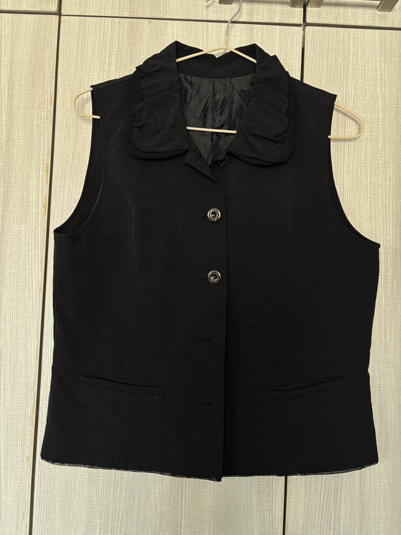 Black Sleeveless Vest with Ruffle Collar (Category: Sleeveless) located in Taguig. Submitted by danammn (Listing ID 1439504204, Image 1). Description: - Black sleeveless vest - Ruffle collar design - Three-button closure - Two front pockets - Smooth, woven fabric - Perfect for layering or wearing alone - Adds a touch of sophistication Flat lay measurements: Bust: 17in Waist: 16in MOP: GCash / Bank transfer Shipping c/o buyer. NO MEET-UPS! Locatio
