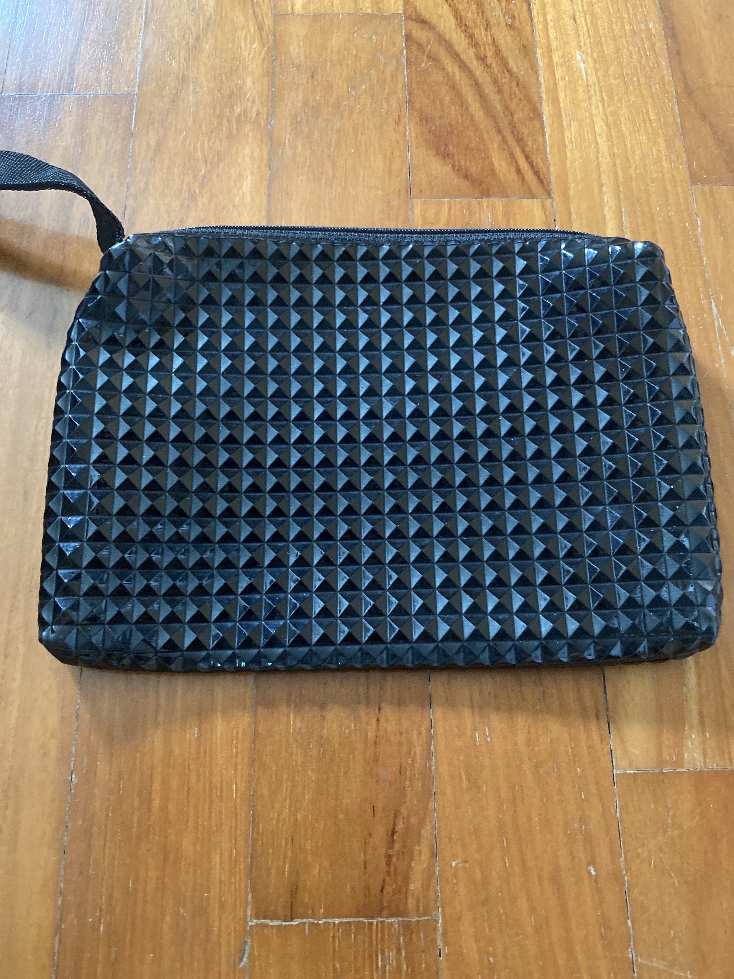 Black Studded Clutch Bag (Category: Clutches) located in Singapore. Submitted by hthappyqq (Listing ID 1439508518, Image 1). Description: - Stylish black clutch bag - Unique studded design - Zippered closure - Includes a small strap - Clean and well-maintained interior - Great for carrying essentials - Perfect for nights out and special occasions.
