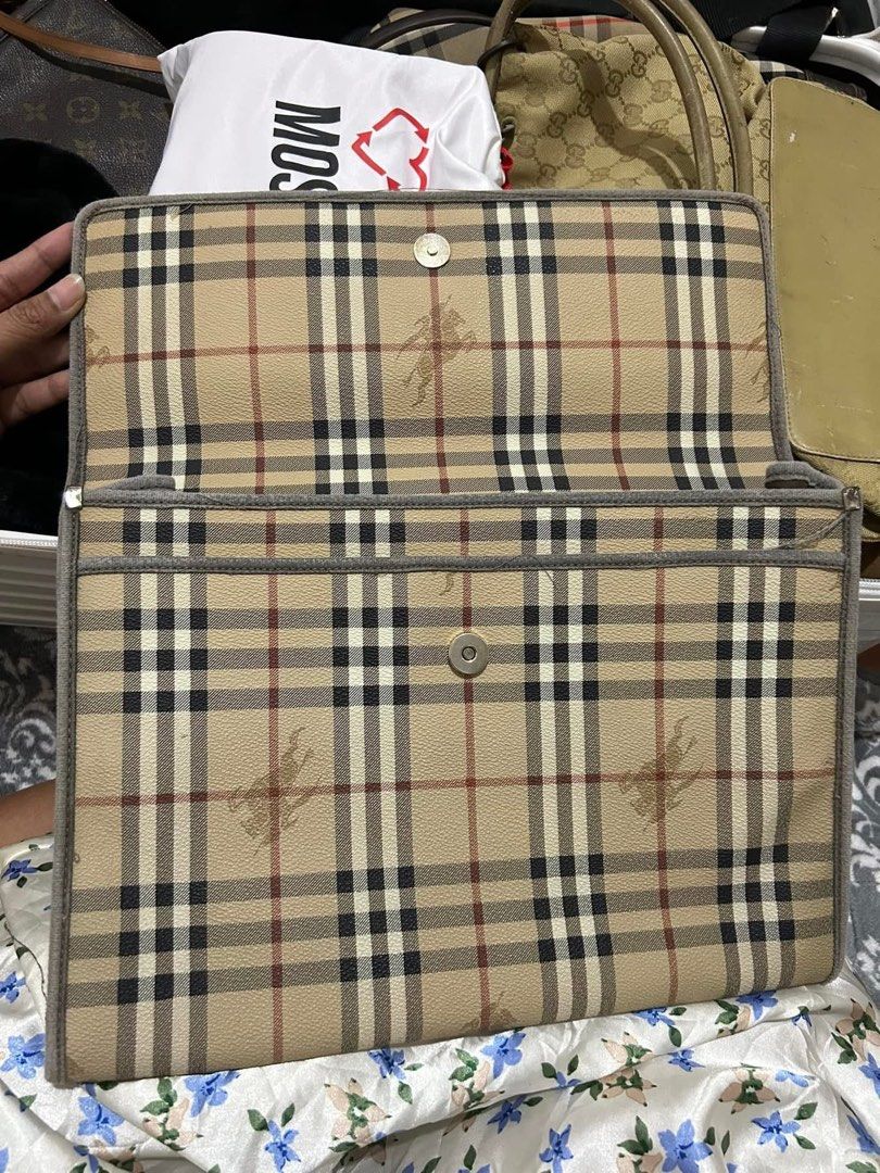 Burberry Clutch Bag (Category: Luxury Bags & Wallets) located in Manaoag. Submitted by fortheloveofbagsph (Listing ID 1439554393, Image 3). Description: - Authentic Burberry clutch bag - Iconic check pattern - Brown leather logo patch - Interior zipper pocket - "Burberry of London Made in Italy" leather tag - Magnetic closure.