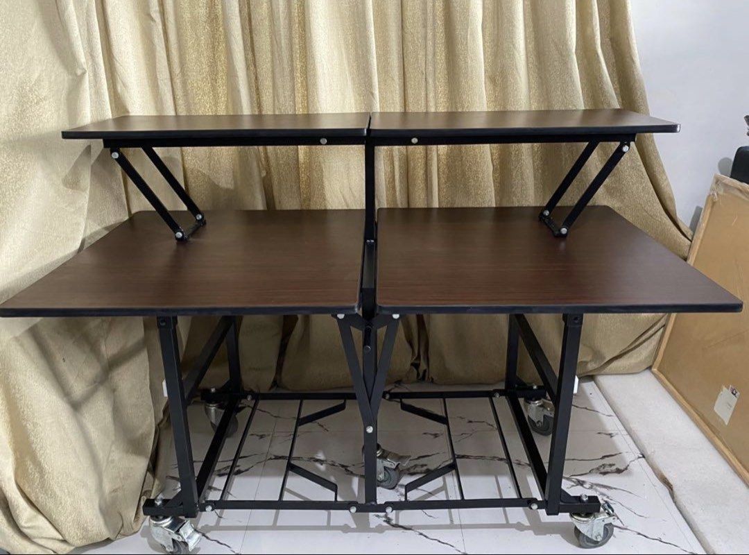 Catering table (Category: Tables & Sets) located in Binan City. Submitted by rgmofficefurniture (Listing ID 1439461521, Image 1). Description: - Dark wood-grain finish - Sturdy black metal frame - Two-tier design - Mounted on wheels for easy mobility - Foldable for convenient storage - Suitable for various uses .