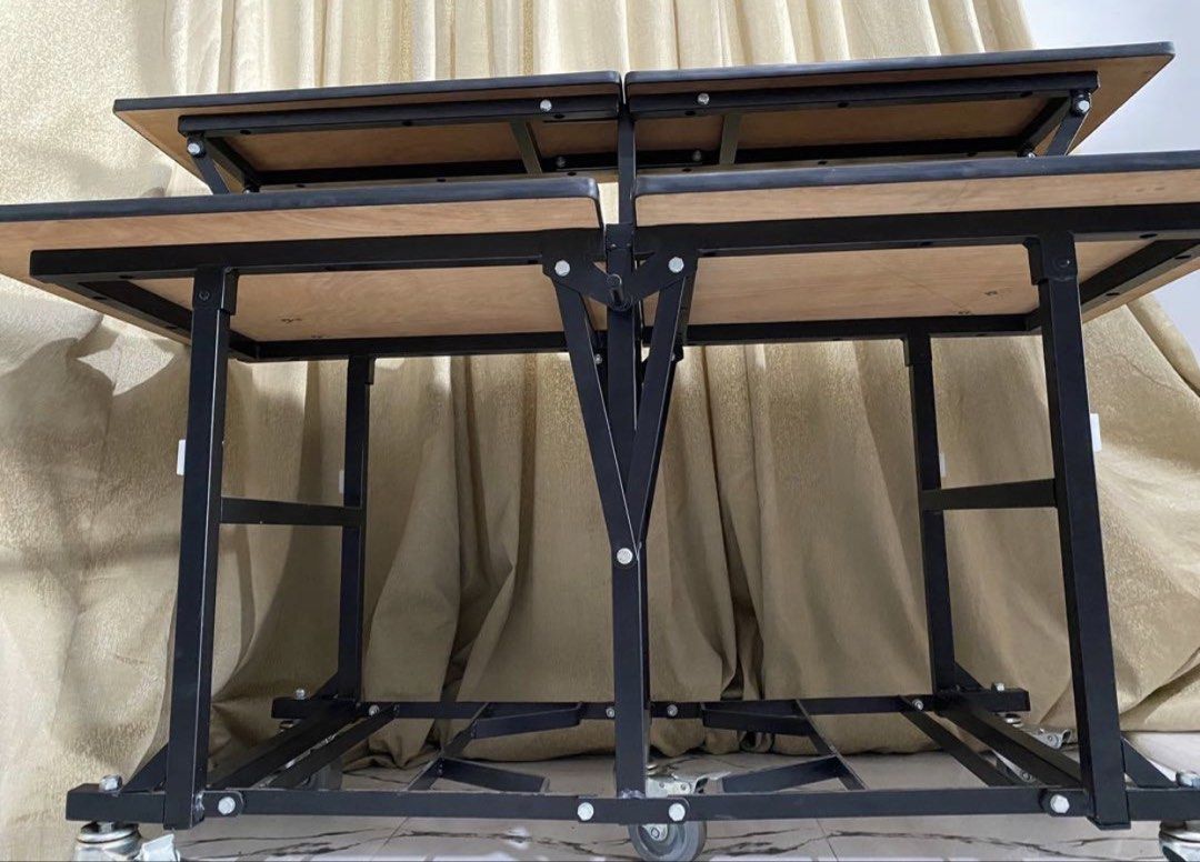 Catering table (Category: Tables & Sets) located in Binan City. Submitted by rgmofficefurniture (Listing ID 1439461521, Image 3). Description: - Dark wood-grain finish - Sturdy black metal frame - Two-tier design - Mounted on wheels for easy mobility - Foldable for convenient storage - Suitable for various uses .