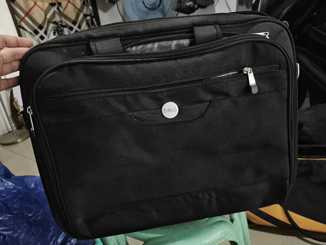 Dell Laptop Bag - Black (Category: Laptop Bags & Sleeves) located in Del Monte. Submitted by anitagalan89774 (Listing ID 1439443838, Image 2). Description: - Black Dell laptop bag - Multiple compartments and zippers - Features a carrying handle - Dell logo on the front - Made of durable fabric - Includes a front pocket and main compartment - Designed for laptops and accessories.