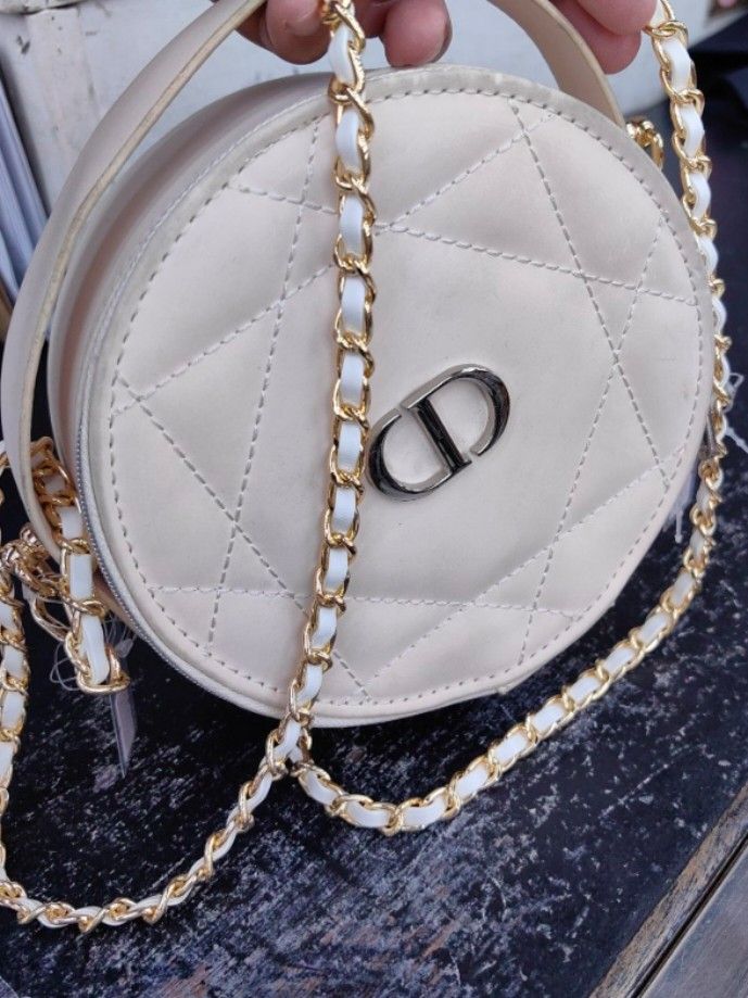 Dior Round Crossbody Bag (Category: Luxury Bags & Wallets) located in Quezon City. Submitted by flat.earther23 (Listing ID 1439489899, Image 1). Description: - Cream-colored, quilted crossbody bag - Features a silver-tone CD logo - Gold chain strap with white leather accents - Dior branded zipper pull - Cream-colored, clean interior.