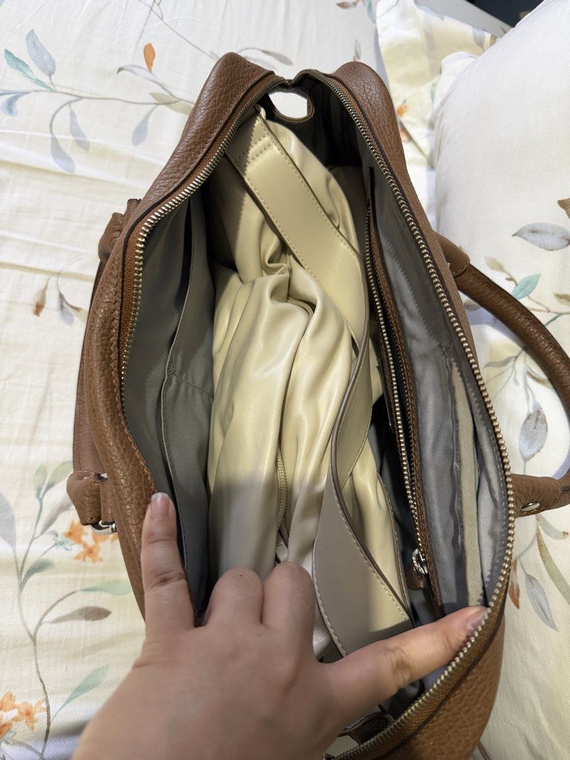 FINO Leatherware Brown Handbag (Category: Luxury Bags & Wallets) located in Paranaque City. Submitted by riannep (Listing ID 1439475856, Image 3). Description: - Brand: FINO Leatherware - Material: Genuine brown leather - Design: Top handle handbag - Closure: Zipper closure for main compartment and exterior pocket - Features: Multiple interior compartments for organization - Shape: Rectangular - Exterior: Textured leather finish - Details: Metal 