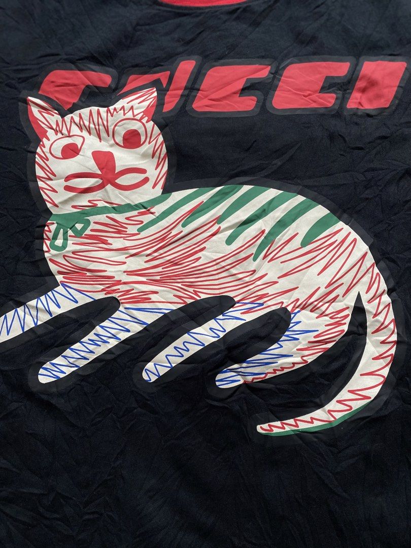 Gucci Cat Graphic T-shirt (Category: Tshirts & Polo Shirts ) located in Iloilo. Submitted by illcitythriftedco. (Listing ID 1439565488, Image 2). Description: - Eye-catching cat graphic on the front - Red collar and Gucci logo in red - Includes tiger graphic tag - Size: Medium.