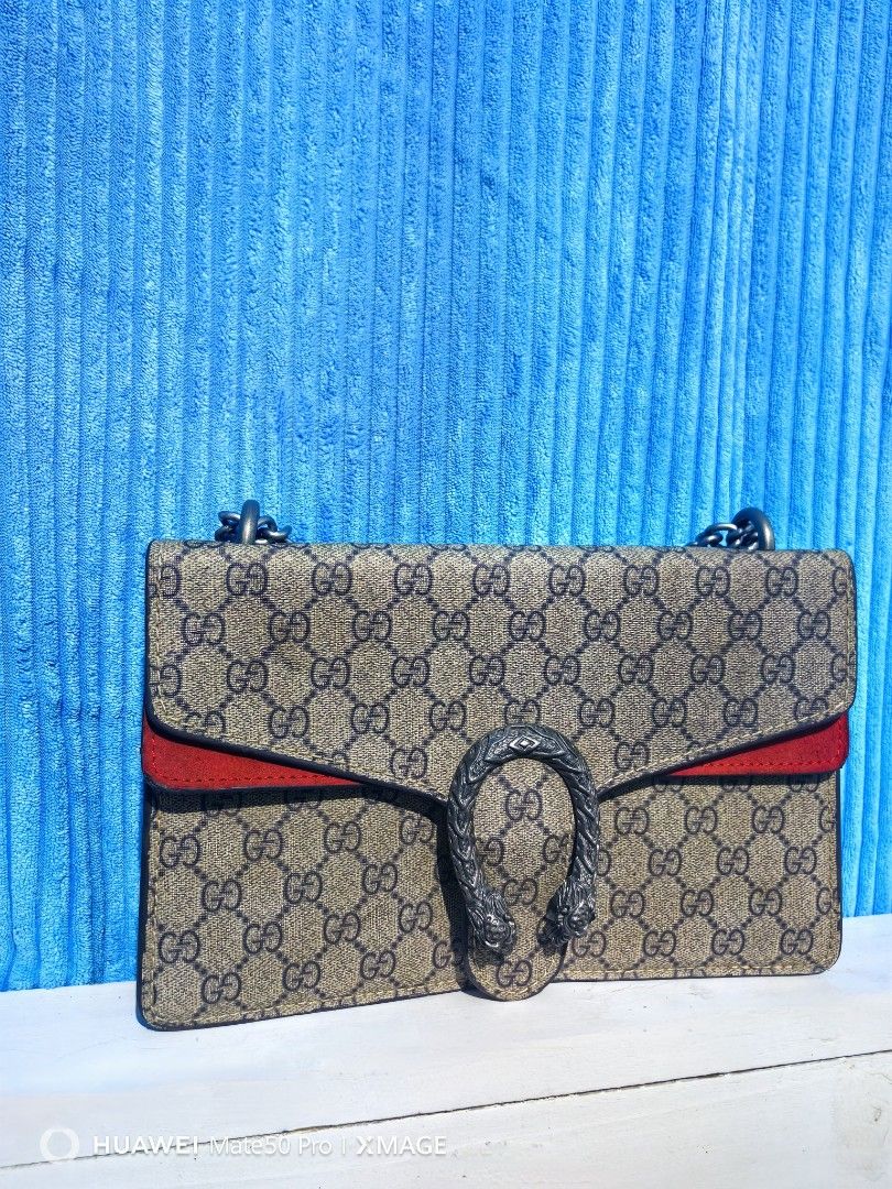 Gucci Dionysus Shoulder Bag (Category: Luxury Bags & Wallets) located in Villasis. Submitted by mysticforest.bb2b4b (Listing ID 1439522274, Image 1). Description: - Authentic Gucci Dionysus shoulder bag - Iconic tiger head closure - Chain strap - Red suede flap and interior - Interior zipped pocket - Classic Gucci monogram canvas exterior -Made in Italy.