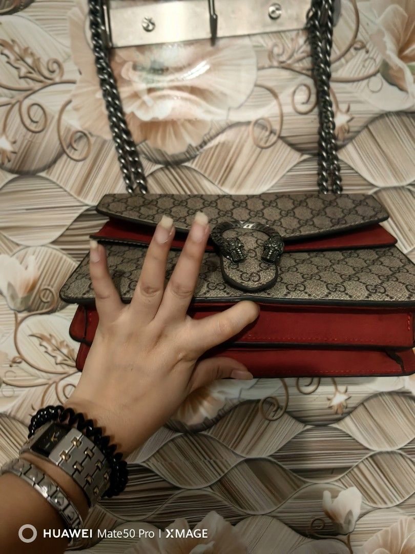 Gucci Dionysus Shoulder Bag (Category: Luxury Bags & Wallets) located in Villasis. Submitted by mysticforest.bb2b4b (Listing ID 1439522274, Image 3). Description: - Authentic Gucci Dionysus shoulder bag - Iconic tiger head closure - Chain strap - Red suede flap and interior - Interior zipped pocket - Classic Gucci monogram canvas exterior -Made in Italy.