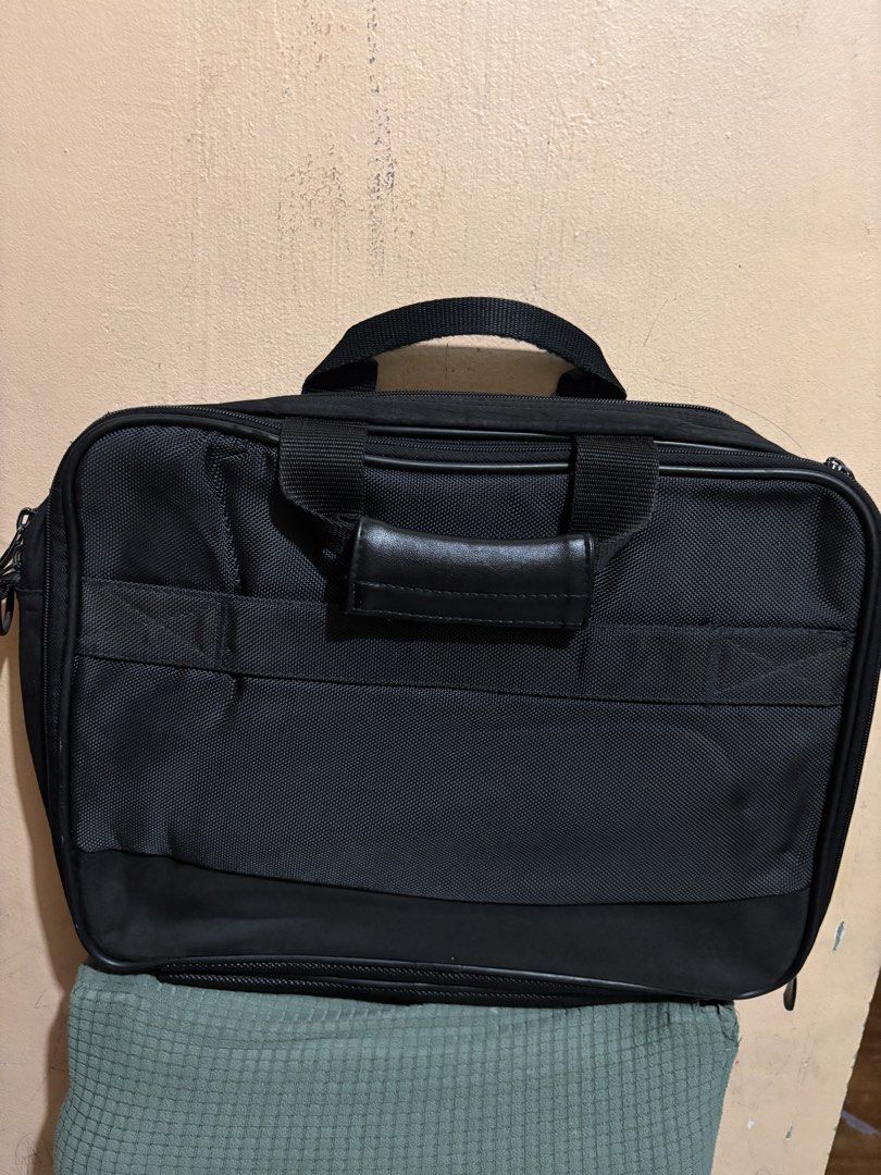 HP Laptop Bag (Category: Laptop Bags & Sleeves) located in San Fernando. Submitted by ladychinita07 (Listing ID 1439452565, Image 2). Description: - Black HP laptop bag - Multiple compartments for organization - Includes handle and shoulder strap - Features front pocket with HP logo - Durable material - Visible zippers on sides and top.