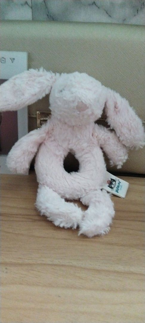 Jellycat Pink Bunny Rattle (Category: Toys & Games) located in Caloocan City. Submitted by izzyjelly (Listing ID 1439508380, Image 1). Description: Adorable Jellycat bunny rattle is a soft and cuddly toy. It features a pink color and a unique ring-shaped body. The bunny has long floppy ears and a cute face. The tag indicates it is made in China. Perfect for babies and young children. Location📍North Caloocan MOD: Lalamove or JnT MOP: Gcash ✅Can s