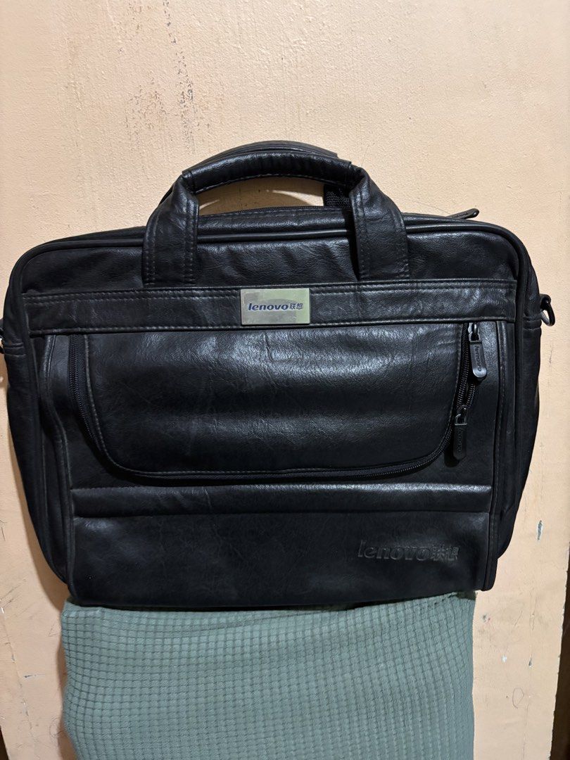 Lenovo Laptop Bag leather (Category: Laptop Bags & Sleeves) located in San Fernando. Submitted by ladychinita07 (Listing ID 1439453482, Image 1). Description: - Black Lenovo laptop bag - Multiple compartments for storage - Includes a handle and a shoulder strap - Features a zippered front pocket - Interior with Lenovo logo - Secure zipper closure - Made of a durable, leather-like material.