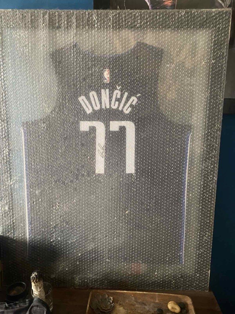 Luka Doncic w/ Panini Authentics Autographed Mavericks Jersey (Category: Activewear) located in Manila. Submitted by xtianlim2727 (Listing ID 1439560137, Image 1). Description: - Authentic Luka Dončić autographed navy Dallas Mavericks swingman jersey. - Includes Certificate of Authenticity (COA) from Panini Authentic. - Features Dončić's name and number 77. - Signature is visible on the jersey. - Jersey is sealed in protective packaging. 55k or b