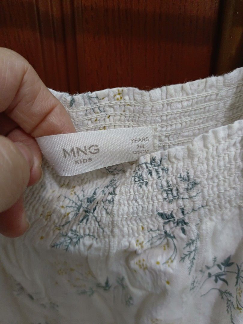 MNG Kids Floral Dress (Category: Babies & Kids Fashion) located in San Pedro. Submitted by aey04 (Listing ID 1439524213, Image 2). Description: - MNG Kids white dress with floral print - Features a square neckline - Ruffled sleeves - Smocked bodice - Flowing skirt - Suitable for girls aged 7-8 years old (128cm height) - Ideal for casual wear.