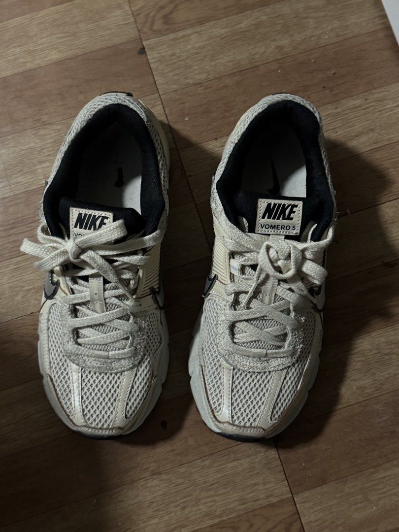 Nike Zoom Vomero 5 Sneakers (Category: Sneakers) located in Manila. Submitted by welllovedstuff03 (Listing ID 1439605459, Image 2). Description: Nike Zoom Vomero 5 sneakers in a cream and black colorway. Features the Nike swoosh on the sides. The shoes have mesh detailing and a cushioned sole. The tongue of the shoe has the Nike logo and the words "Vomero 5"..