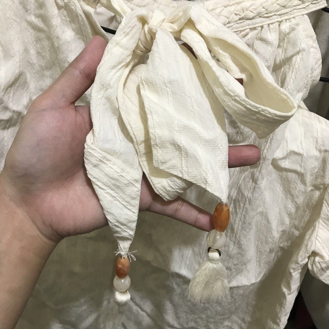 Off-Shoulder cream top with tie (Category: Blouses) located in Manila. Submitted by bbeeaa (Listing ID 1439548859, Image 3). Description: - thrifted (not yet washed) - issue: may yellowish stain sa collar part (washable) - high quality fabric.
