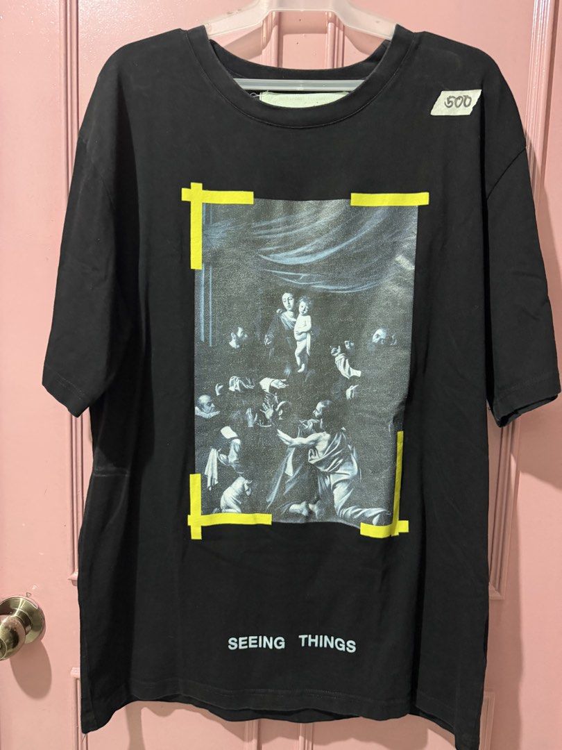 Off-White Seeing Things T-shirt (Category: Tshirts & Polo Shirts ) located in Pasig City. Submitted by inmyclosetbyj (Listing ID 1439601739, Image 1). Description: - Off-White T-shirt - Graphic print on front - Features a yellow frame and "SEEING THINGS" text - Crew neck - Short sleeves - Tag visible - Size not specified.