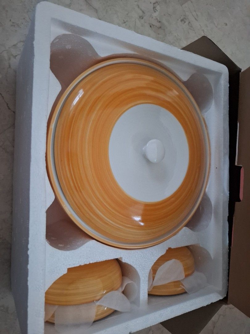 Orange Ceramic Serving Dish Set (Category: Dinnerware & Cutlery) located in Singapore. Submitted by stunt1 (Listing ID 1439527992, Image 1). Description: - Brand new serving dish set - Includes 1 large serving dish with lid and 2 smaller bowls - Features a unique orange and white design - Ideal for serving food at gatherings or daily meals - Comes in original packaging.