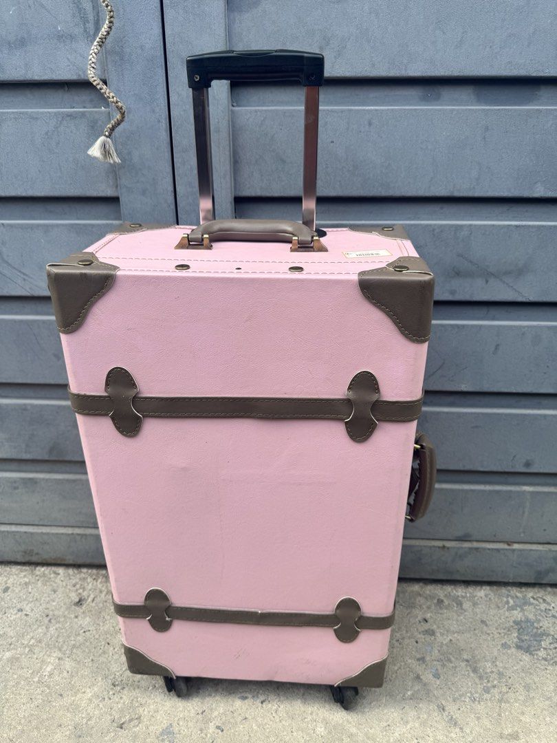Pink Rolling Suitcase (Category: Luggage) located in Taguig. Submitted by 5jsjapansurplustaguig. (Listing ID 1439435598, Image 1). Description: - Pink rolling suitcase with brown accents - Vintage-style design - Retractable handle and wheels for easy transport - Corner protectors for durability - Top handle for carrying - Interior straps to secure contents - Ideal for travel.
