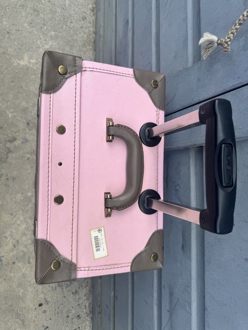 Pink Rolling Suitcase (Category: Luggage) located in Taguig. Submitted by 5jsjapansurplustaguig. (Listing ID 1439435598, Image 2). Description: - Pink rolling suitcase with brown accents - Vintage-style design - Retractable handle and wheels for easy transport - Corner protectors for durability - Top handle for carrying - Interior straps to secure contents - Ideal for travel.