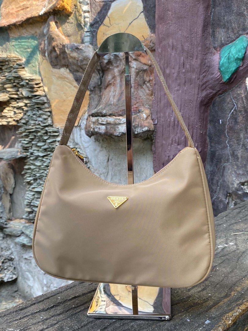 Prada Hobo Bag (Category: Luxury Bags & Wallets) located in Dagupan City. Submitted by retro.plug (Listing ID 1439562320, Image 1). Description: - Sleek nylon exterior - Gold-tone Prada logo - Secure zipper closure - Versatile neutral color - Comfortable shoulder strap - Includes Prada label inside.