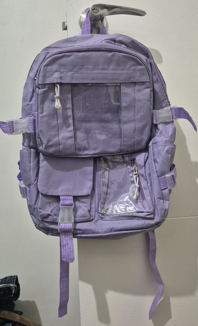 Purple Backpack with Multiple Pockets (Category: Backpacks) located in Mandaluyong City. Submitted by lauracmendoza (Listing ID 1439547170, Image 1). Description: - Purple backpack - Multiple pockets and compartments for organized storage - Adjustable straps and buckles - Main compartment and smaller pockets with clear windows - Durable, textured material - Padded straps for comfort.