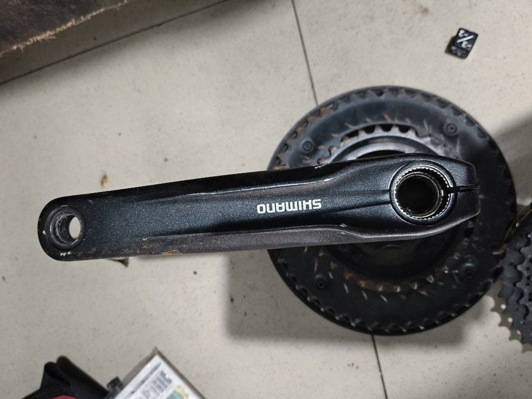 Shimano Cassette and Crankset (Category: Bicycles) located in Del Monte. Submitted by anitagalan89774 (Listing ID 1439421390, Image 2). Description: - Used Shimano cassette - Visible rust on cassette - Used Shimano crankset - Shimano logo on crankset - Single chainring on crankset - Likely for bicycle use.