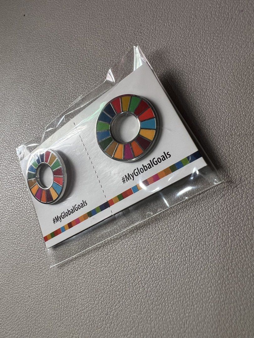 Sustainable Development Goal (SDG) lapel pins (Category: Community) located in Valenzuela. Submitted by blvckcat__ (Listing ID 1439485005, Image 1). Description: - Features a colorful, segmented circular design - Includes a card with the #MyGlobalGoals hashtag - Brand new, sealed in plastic packaging.