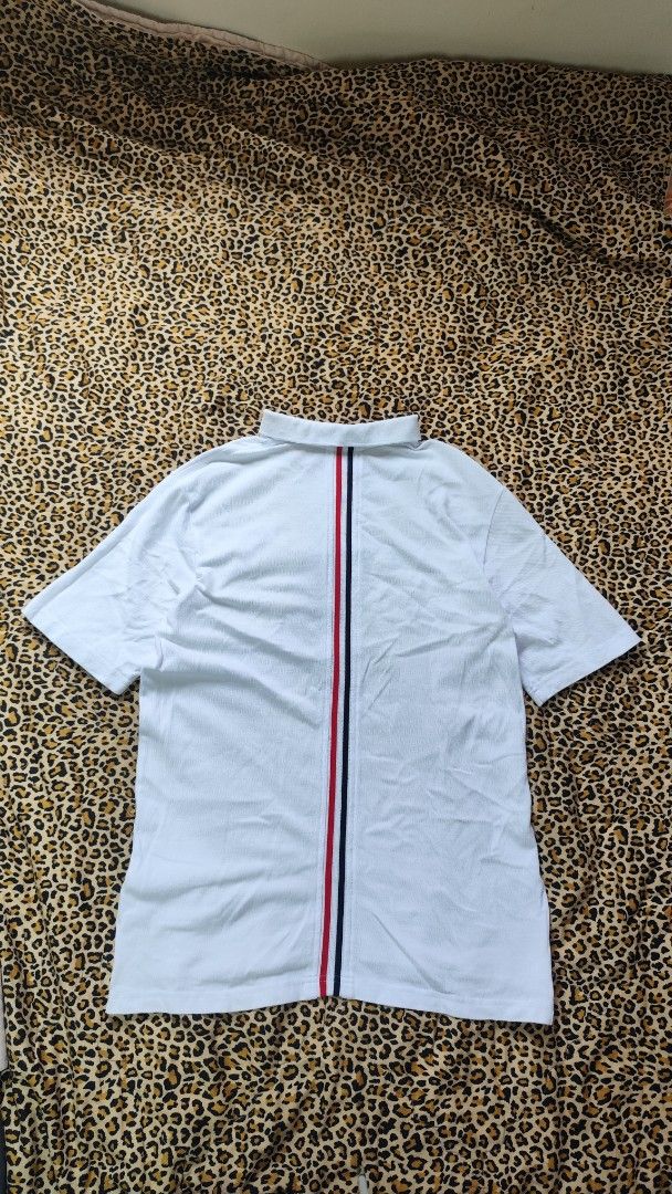 Thom Browne Polo Shirt Size 1 (Category: Tshirts & Polo Shirts ) located in San Jose. Submitted by galitsabarat (Listing ID 1439501927, Image 3). Description: - White Thom Browne polo shirt - Classic polo collar with red, white, and blue stripes - Button-down placket - Short sleeves - Back features vertical red, white, and blue stripe design - Size 1 on tag - Dimensions: 18x26.