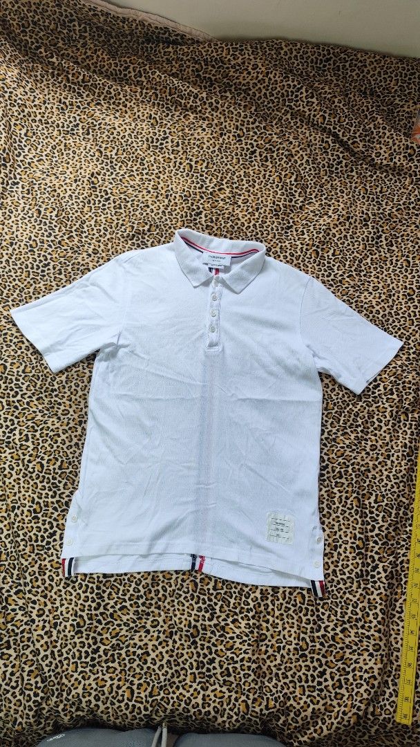 Thom Browne Polo Shirt Size 1 (Category: Tshirts & Polo Shirts ) located in San Jose. Submitted by galitsabarat (Listing ID 1439501927, Image 2). Description: - White Thom Browne polo shirt - Classic polo collar with red, white, and blue stripes - Button-down placket - Short sleeves - Back features vertical red, white, and blue stripe design - Size 1 on tag - Dimensions: 18x26.