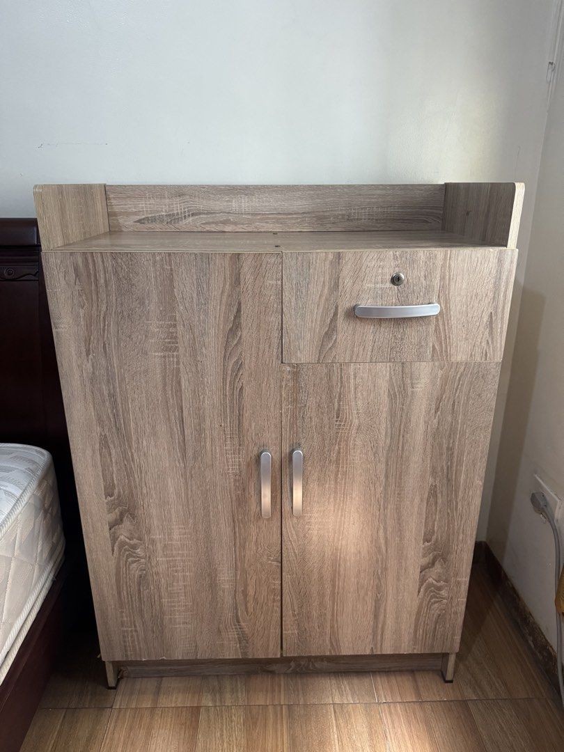 Wooden Cabinet with Drawer (Category: Shelves, Cabinets & Racks) located in Mandaluyong City. Submitted by winx3 (Listing ID 1439435590, Image 1). Description: - Wooden cabinet with two doors and a drawer - Light brown wood grain finish - Top shelf depth: 14 inches - Width: 43 inches - Height: 30 inches - Features silver handles - Drawer includes a lock.