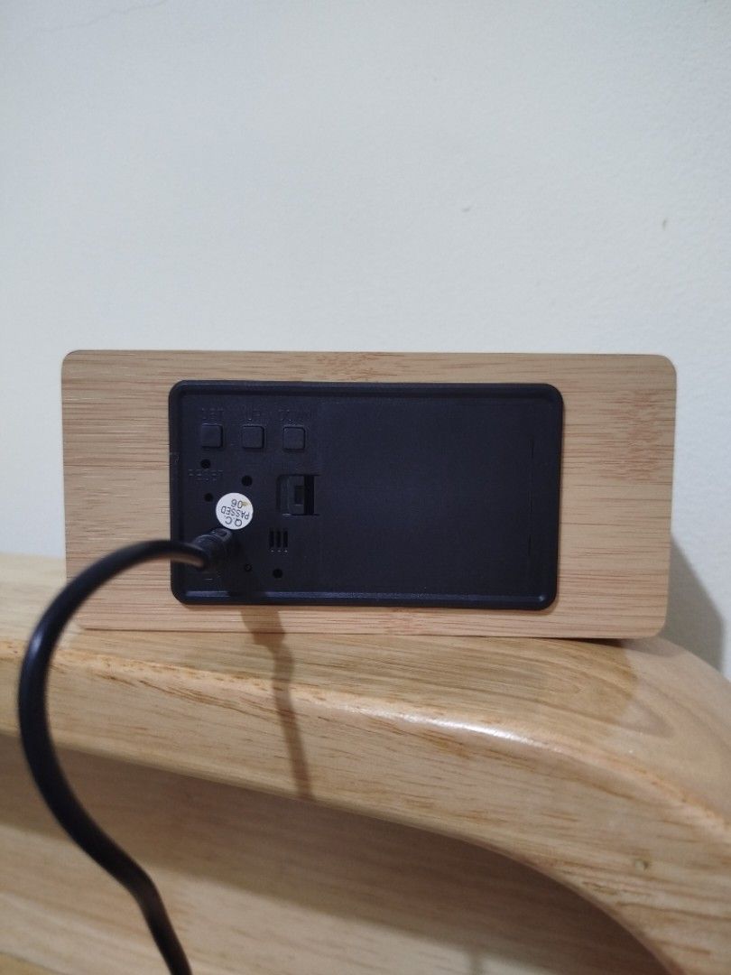 Wooden Digital Clock with Wireless Charger (Category: Clocks) located in Quezon City. Submitted by luckycitrine (Listing ID 1439527303, Image 2). Description: - Wooden digital alarm clock - Displays time and temperature - Wireless charging pad on top - Easy-to-use time setting buttons - Power options: DC 5V adapter or 4 AAA batteries - Comes with box and manual - Brand new and unused, only tested to see if working - Grab/Lalamove from Novaliches.