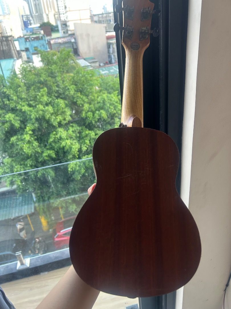Yael Ukulele (Category: Musical Instruments) located in Cavite. Submitted by thriftqueen.phhhhh (Listing ID 1439502014, Image 3). Description: - Brown ukulele with four strings. - Features a round sound hole. - Dark brown finish. - Lighter-colored neck. - Brand name visible..