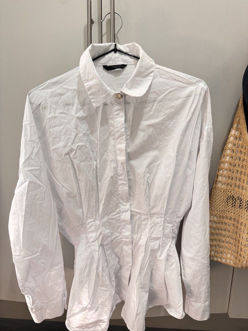 Zara Pleated Poplin Shirt - White (Category: Shirts) located in Rosales. Submitted by thriftingismygame (Listing ID 1439476183, Image 3). Description: White poplin shirt from Zara. Features a collared neckline, long sleeves, and pleated detailing. The shirt has a fitted waist and button-down closure. Made in Morocco. Size S..