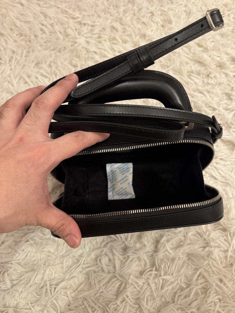AMI Alexandre Mattiussi Black Handbag (Category: Luxury Bags & Wallets) located in San Pedro. Submitted by julio_sibulo (Listing ID 1439789062, Image 3). Description: - AMI Alexandre Mattiussi black handbag - Top handle and detachable shoulder strap - Front pocket with AMI logo - Clean interior - Rectangular shape, structured design - Silver-toned hardware.