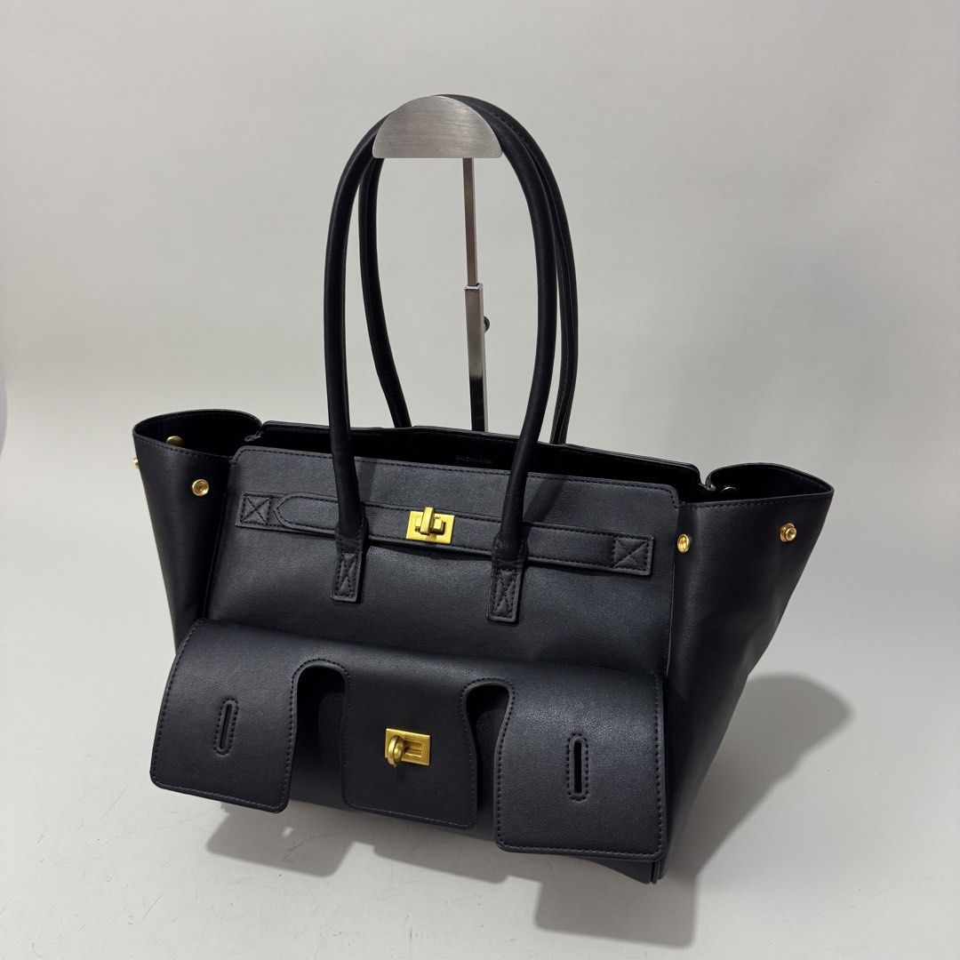 Balenciaga Black Leather Tote Bag (Category: Luxury Bags & Wallets) located in Dagupan City. Submitted by thriftygoods.dagupan (Listing ID 1439608855, Image 2). Description: - Balenciaga black leather tote bag - Structured design - Front flap pocket - Gold-tone hardware - Top handles - Made in Italy.