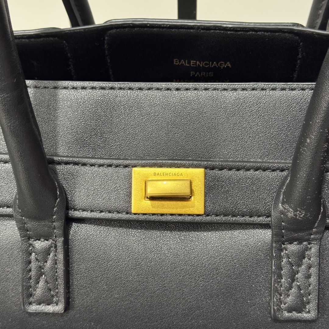 Balenciaga Black Leather Tote Bag (Category: Luxury Bags & Wallets) located in Dagupan City. Submitted by thriftygoods.dagupan (Listing ID 1439608855, Image 3). Description: - Balenciaga black leather tote bag - Structured design - Front flap pocket - Gold-tone hardware - Top handles - Made in Italy.