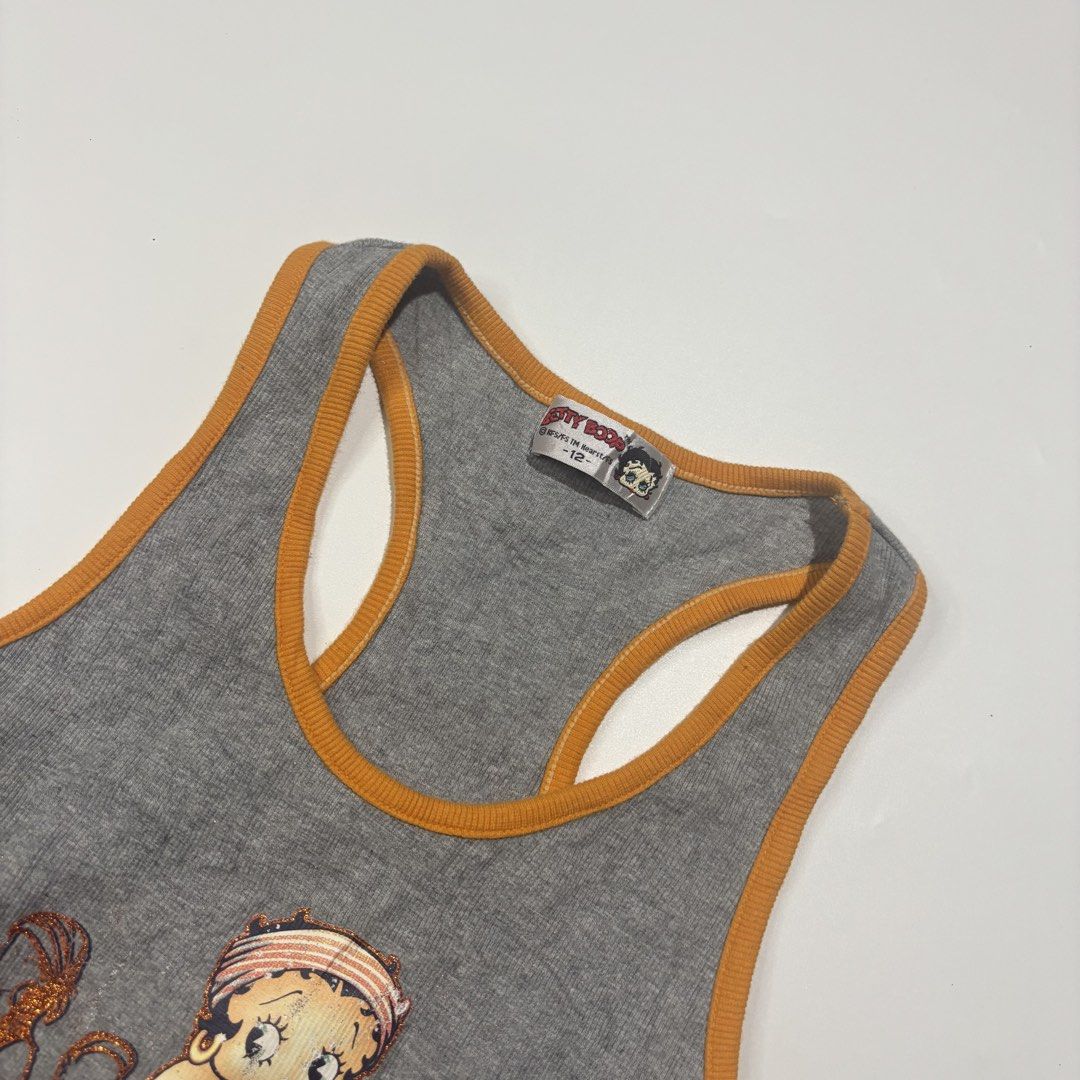 Betty Boop Tank Top (Category: Sleeveless) located in Cebu City. Submitted by kidfrom6000 (Listing ID 1439770442, Image 2). Description: Gray tank top featuring a Betty Boop graphic. It has an orange trim and a racerback design. The graphic includes the text "2004 Spring & Summer Singer 'Betty Show'". The tag indicates a size 12. Dimensions can be seen in the picture.