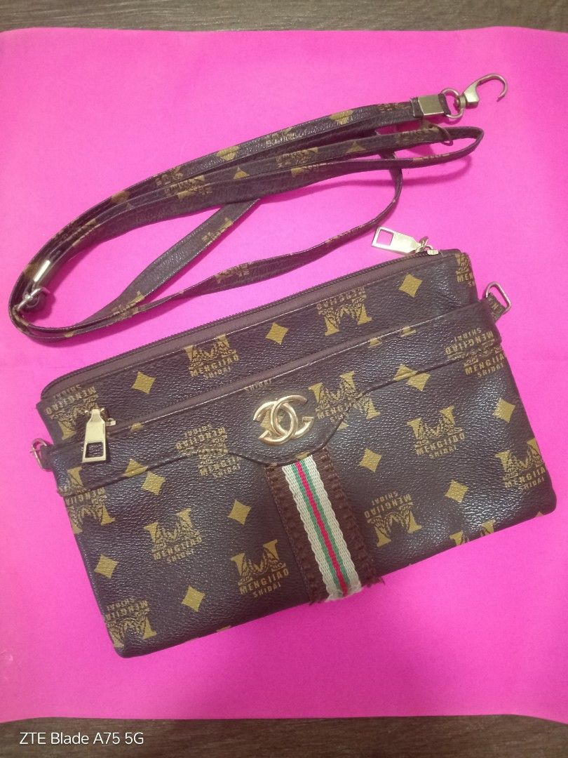 Brown Crossbody Bag/Clutch (Category: Cross-body Bags) located in Binan City. Submitted by criscb (Listing ID 1439646747, Image 1). Description: * Monogram print with multiple zipper compartments. Note: The sling/strap has some slight damage (reflected in the low price!), but it can easily be used as a clutch or swapped out with any standard clip-on strap you already own. * With front & back zipper.