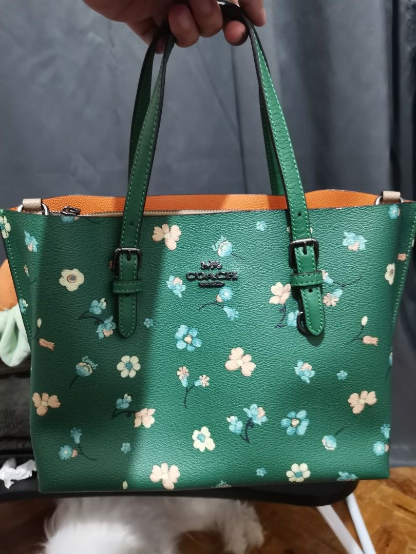 Coach Floral Print Tote Bag (Category: Luxury Bags & Wallets) located in Makati City. Submitted by tgrey (Listing ID 1439726660, Image 1). Description: - Coach tote bag - Vibrant green exterior with floral print - Contrasting orange interior lining - Silver-tone hardware - Coach logo - Medium size - Rectangular shape - Two top handles - Ideal for everyday use.