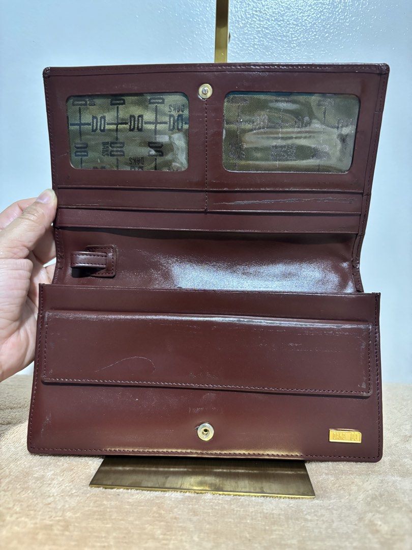 DAKS London Long Wallet Clutch (Category: Wallets & Card holders) located in Pasig City. Submitted by talaversify (Listing ID 1439796914, Image 3). Description: •DAKS London house check long wallet clutch in signature plaid with gold-toned logo plaque •Coated canvas body with premium deep burgundy/maroon leather trim with matching wristlet pull-strap •Spacious and convertible for everyday long wallet or a handheld clutch or a wristlet bag •Can fi