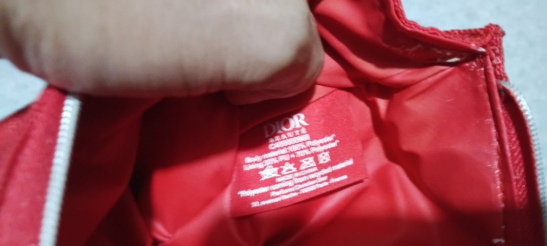 Dior Red Make Up Purse (Category: Luxury Bags & Wallets) located in San Ildefonso. Submitted by rigor32eva20161 (Listing ID 1439733511, Image 3). Description: - Authentic Dior pouch - Vibrant red color - Secure zipper closure with Dior logo - Includes interior Dior label with care instructions - Crafted from durable 100% polyester - Perfect for carrying small essentials - Stylish and functional accessory.