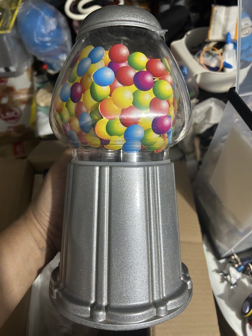 Dubble Bubble Gumball Dispenser Machine (Category: Kids Toys) located in Paranaque City. Submitted by zac.sei (Listing ID 1439642602, Image 2). Description: - Dubble Bubble gumball machine - Clear globe filled with colorful gumballs - Silver-colored metal base - Features a coin slot - Dispensing mechanism included - Base marked "CHINA".