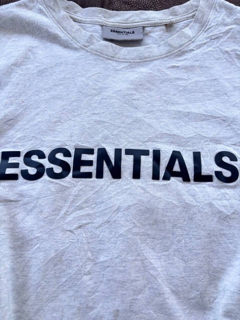 Fear of God Essentials T-shirt (Category: Tshirts & Polo Shirts ) located in Caloocan City. Submitted by wreps (Listing ID 1439615144, Image 2). Description: - Fear of God Essentials T-shirt - Color: Light Gray - Size: L - Features "ESSENTIALS" print on the chest - Made in Vietnam - Material: 100% Cotton - Brand tag and size tag included.