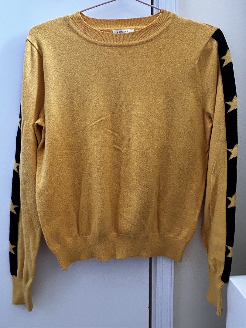 Forever 21 Star Sleeve Sweater (Category: Longsleeves) located in Manila. Submitted by jaynojayno (Listing ID 1439618242, Image 1). Description: - Mustard yellow Forever 21 sweater - Black star detailing on sleeves - Crew neck - Ribbed cuffs and hem - Tag is visible - Comfortable for everyday wear.