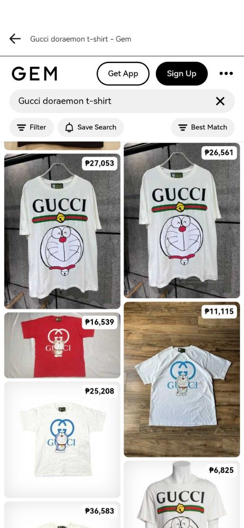 Gucci Doraemon T-shirt (Category: Luxury Apparel) located in Villasis. Submitted by mysticforest.bb2b4b (Listing ID 1439615720, Image 2). Description: - Authentic Gucci T-shirt - Features a Doraemon graphic - Classic white color - Short sleeves and round neckline - Gucci logo prominently displayed - Includes the iconic green and red stripe detail - Made from a lightweight material.