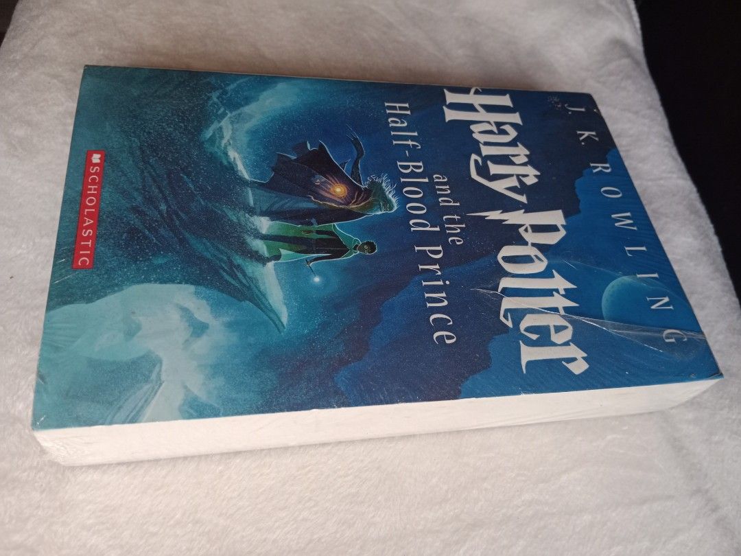 Harry Potter and the Half-Blood Prince (Category: Storybooks) located in Manila. Submitted by angeloarce64172 (Listing ID 1439615921, Image 2). Description: - Harry Potter and the Half-Blood Prince by J.K. Rowling - Published by Scholastic - Brand new, still in original packaging - Cover: Harry Potter and another figure on a cliff - Back: Harry Potter in a library - Spine: White.