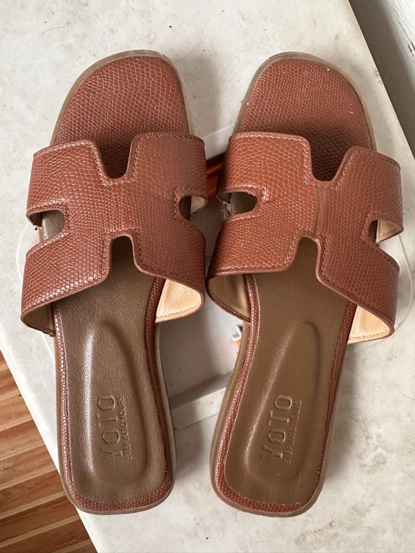 HERMES Oren Sandals Dupe - Brown Size 38 (Category: Flats & Sandals) located in Manila. Submitted by omelette.12 (Listing ID 1439694870, Image 1). Description: - YOTO brand sandals - Brown color - Features an 'H' design on straps - Textured appearance - Flat sole - Suitable for casual wear.