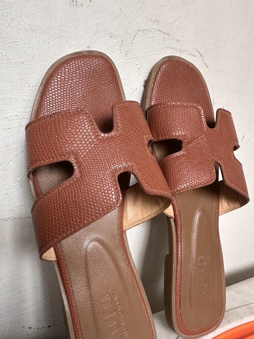 HERMES Oren Sandals Dupe - Brown Size 38 (Category: Flats & Sandals) located in Manila. Submitted by omelette.12 (Listing ID 1439694870, Image 3). Description: - YOTO brand sandals - Brown color - Features an 'H' design on straps - Textured appearance - Flat sole - Suitable for casual wear.