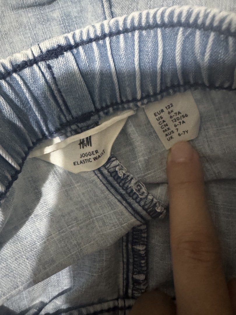 H&M Jogger Elastic Waist Pants (Category: Joggers) located in Mandaluyong City. Submitted by winx3 (Listing ID 1439802046, Image 2). Description: Light blue H&M jogger pants with an elastic waist. Features a drawstring and pockets. The size is indicated as EUR 122, US 6-7A, CA 120/56, MEX 6-7A, AUS 6-7Y, and UK 6-7Y. The pants have a light wash denim appearance..