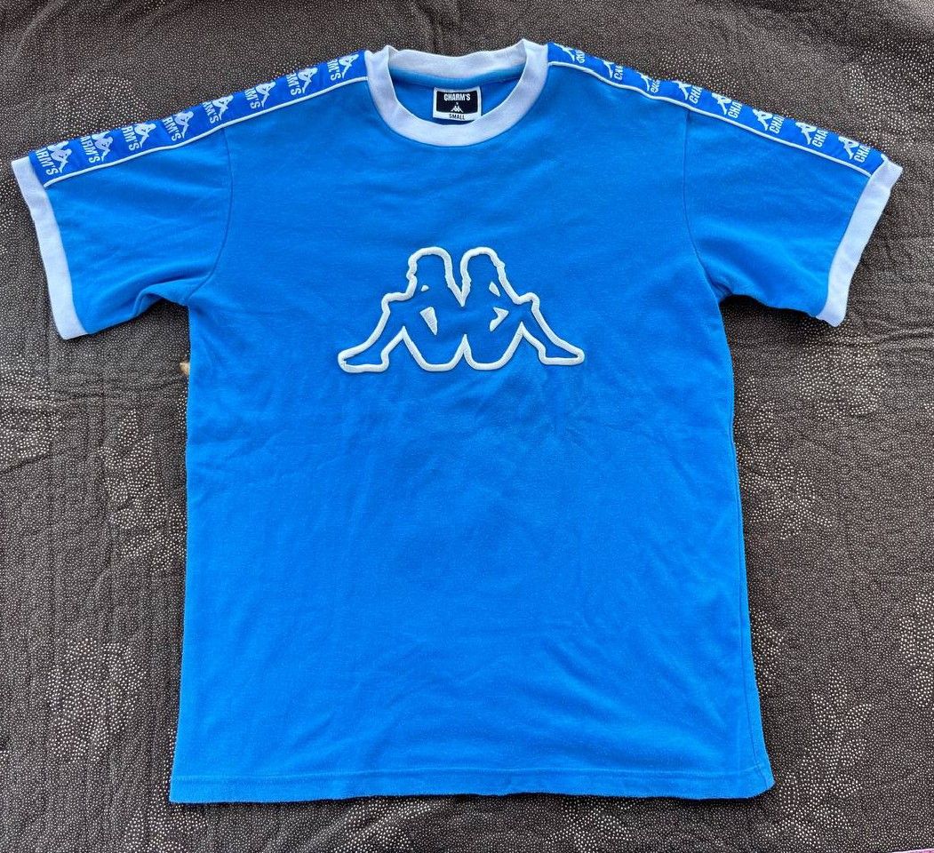 Kappa x Charm's T-shirt - Small (Category: Tshirts & Polo Shirts ) located in Caloocan City. Submitted by wreps (Listing ID 1439615007, Image 1). Description: - Blue Kappa x Charm's T-shirt - Size: Small - Features Kappa logo on front - Charm's branding on sleeves - White collar and sleeve trim.