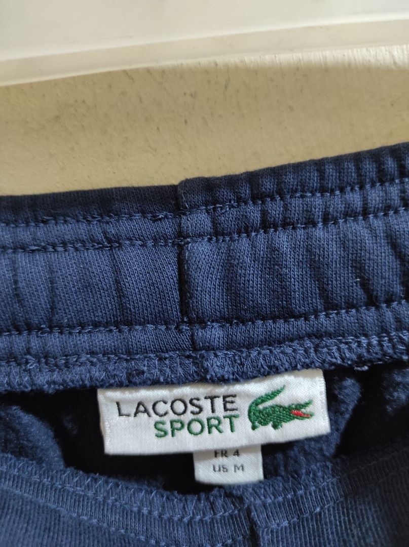 Lacoste Sport Sweatpants - Navy Blue (Category: Joggers) located in Pasay City. Submitted by highkeys (Listing ID 1439715172, Image 2). Description: Navy blue Lacoste Sport sweatpants. Features the Lacoste logo on the front. Includes a drawstring waist. The size is FR 4 / US M. Made with a blend of materials including cotton and polyester. The sweatpants have a relaxed fit, suitable for casual wear or workouts..